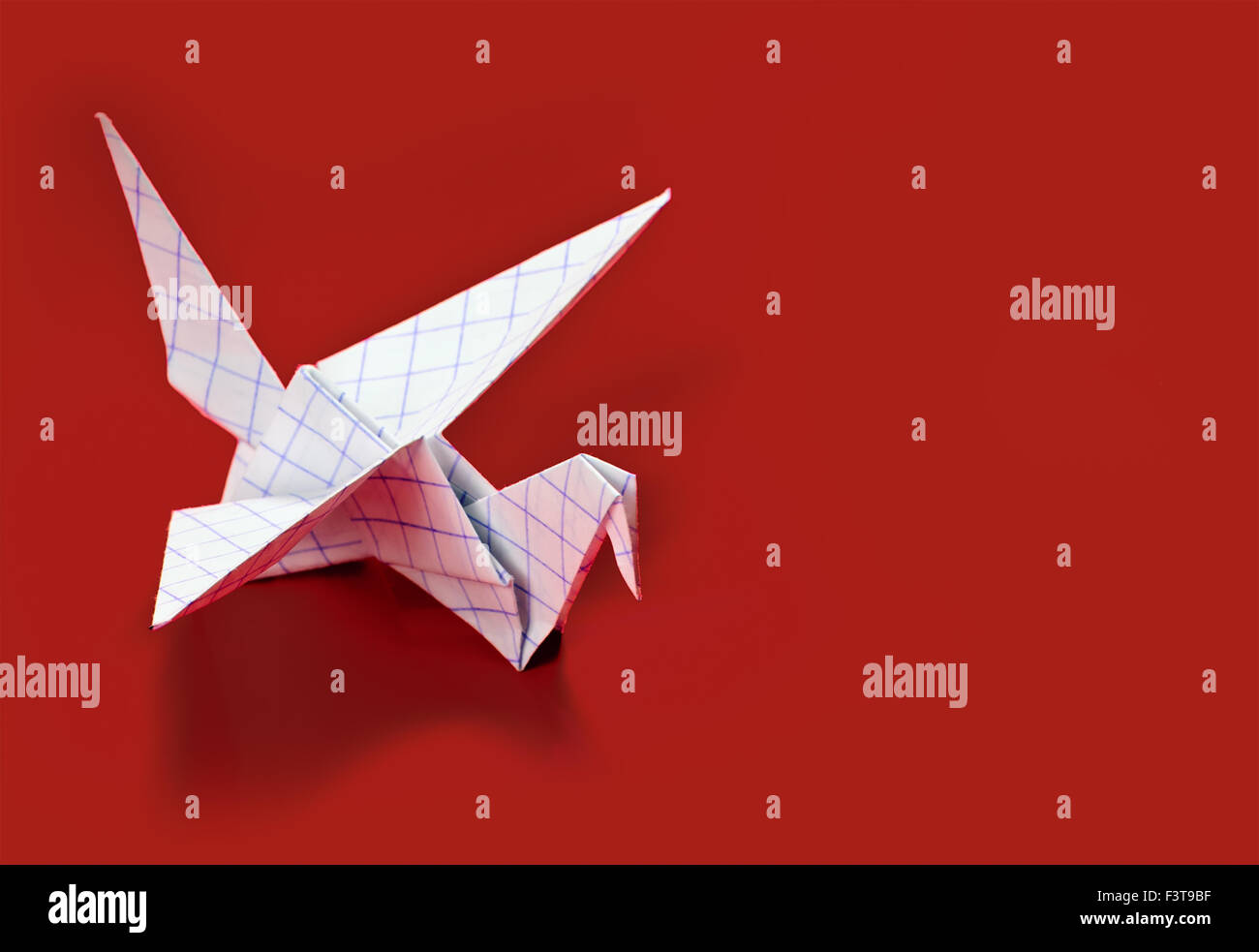 Origami gru su sfondo rosso Foto Stock