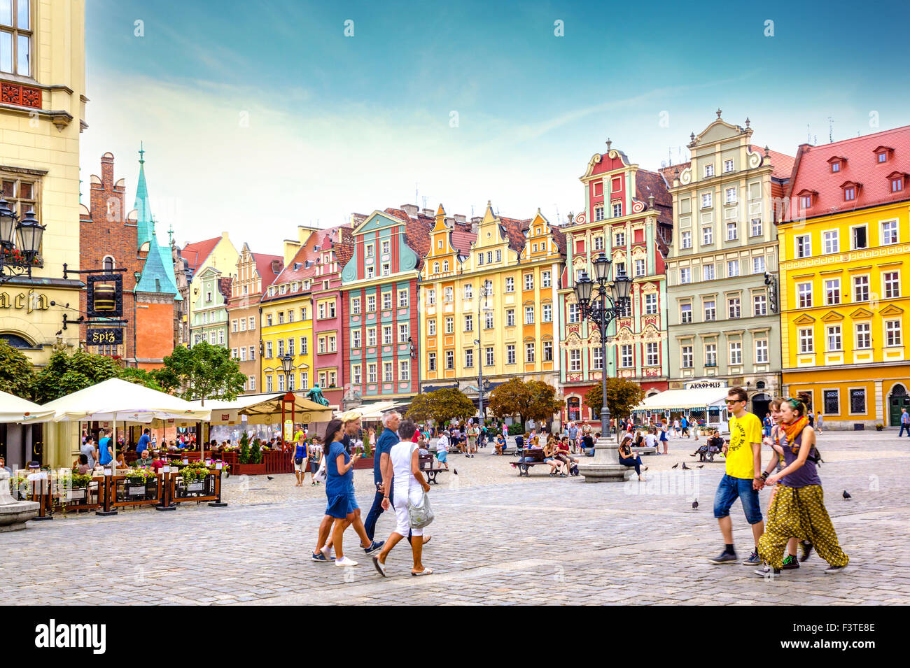 Belle case tenements e turisti a piedi la piazza del vecchio mercato a Wroclaw in Polonia Foto Stock