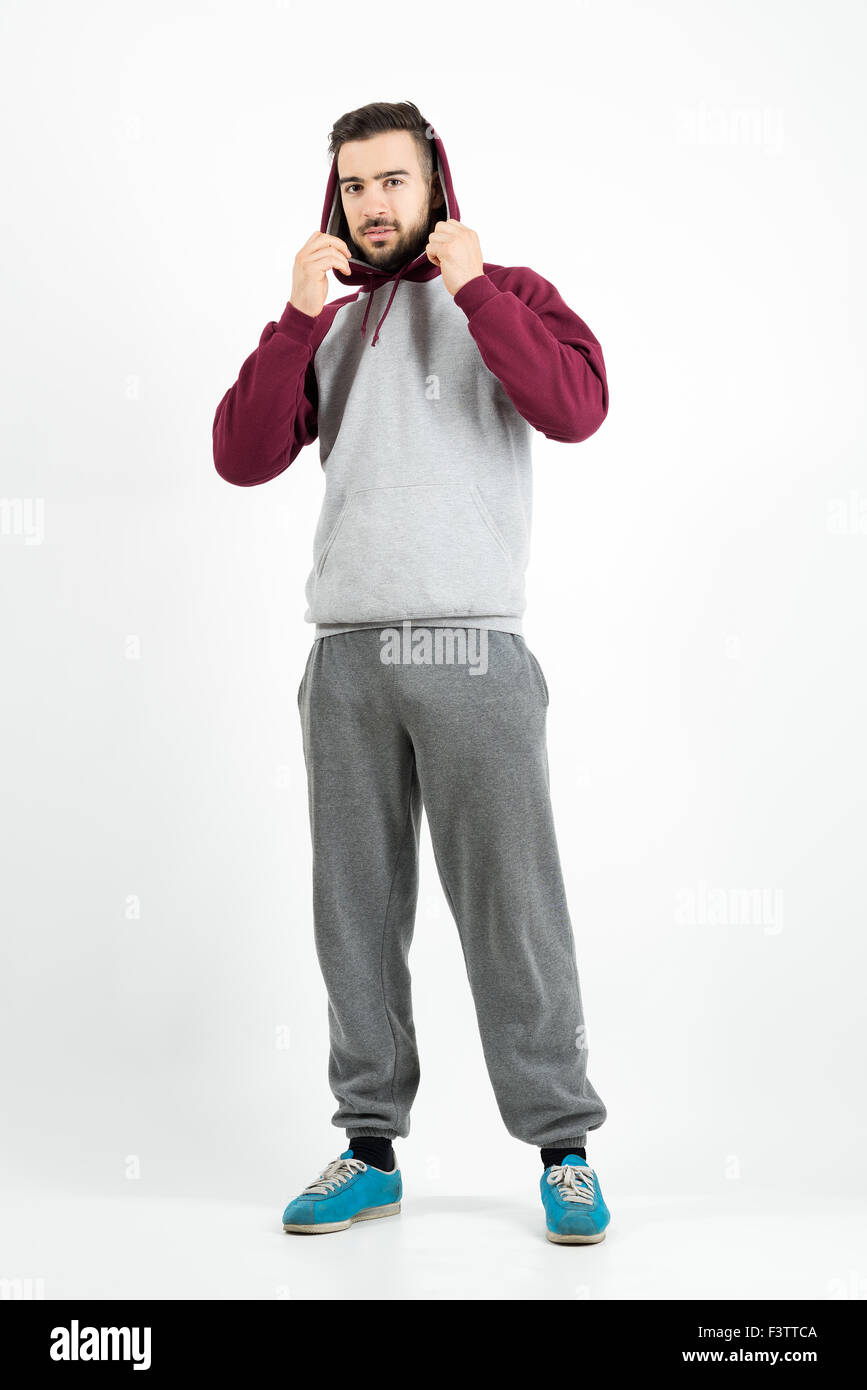 Giovane uomo informale in azienda di abbigliamento sportivo felpa con  cappuccio grigio su sfondo per studio Foto stock - Alamy