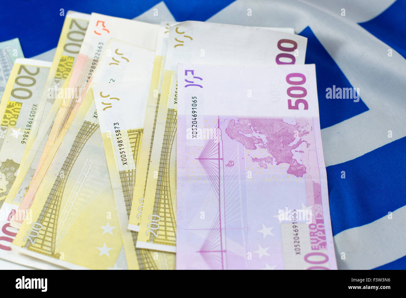 Banconote impilate sulla bandiera greca Foto Stock