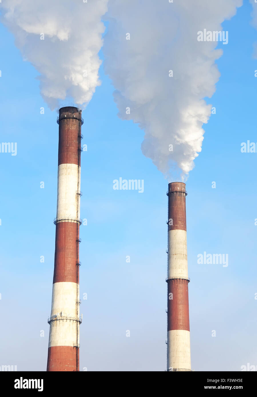 Due comignoli fumanti di impianto di alimentazione Foto Stock