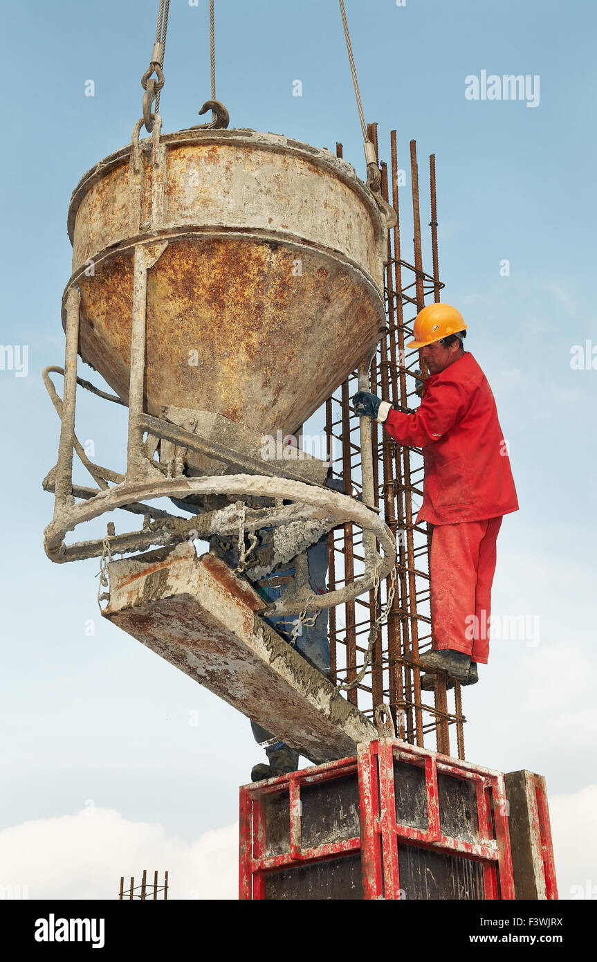 Lavoratori edili la colata di cemento in forma Foto Stock