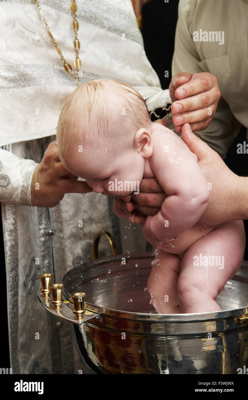Baby Battesimo con acqua in font Foto Stock