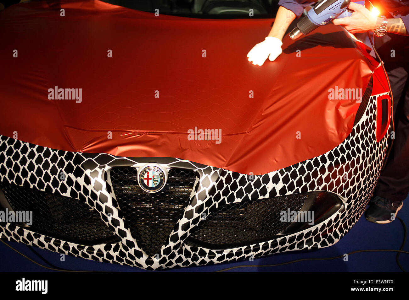 Un Alfa Romeo 4C essendo avvolto in vinile in corrispondenza della apertura  della nuova sede del Garage Italia doganale nella Milano, Italia su Wednesd  Foto stock - Alamy