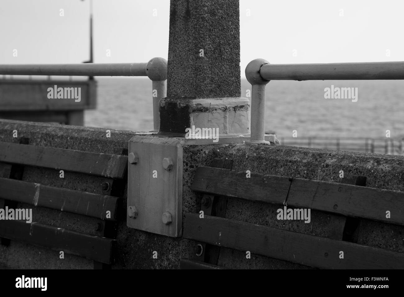 Immagine in bianco e nero del molo di trattativa con il canale in inglese in background, concentrandosi su una staffa di metallo e cemento lampione Foto Stock
