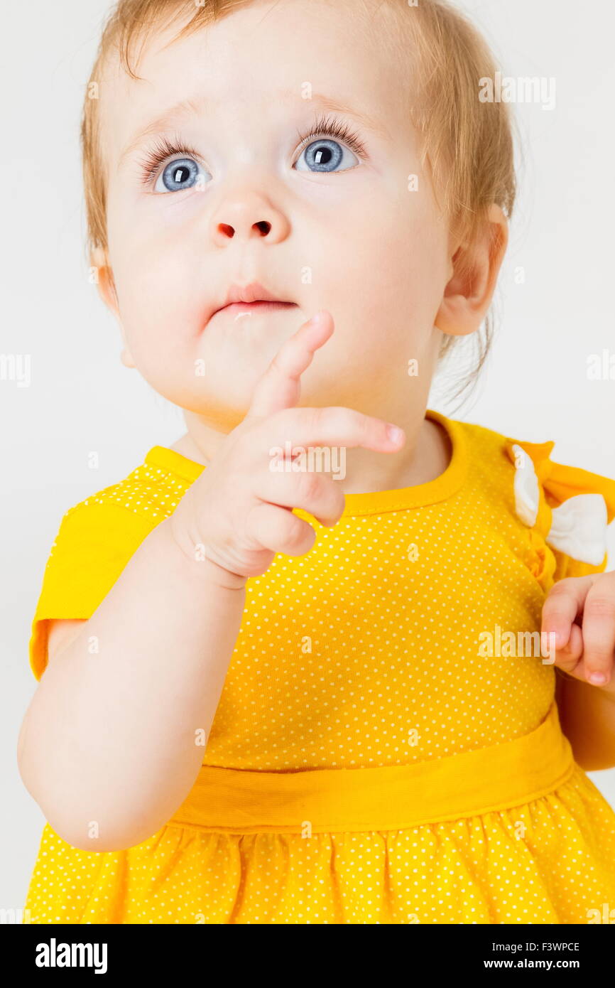 Bambina in abito giallo su sfondo chiaro. Foto Stock