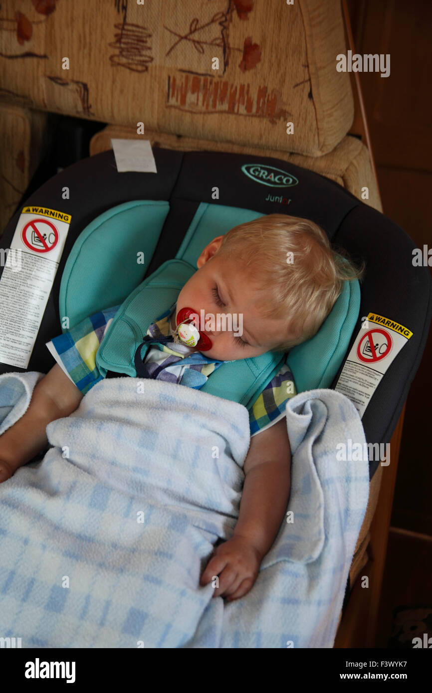 Il Toddler strapped nel sedile auto in fermo motorhome sleeping Foto Stock
