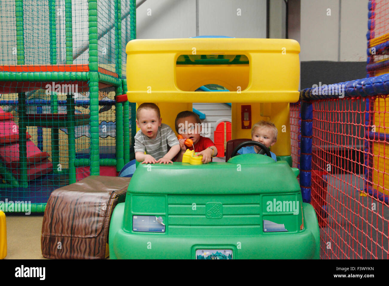 Bambini piccoli e toddler giocando nel motorhome giocattolo in undercover area di gioco Foto Stock