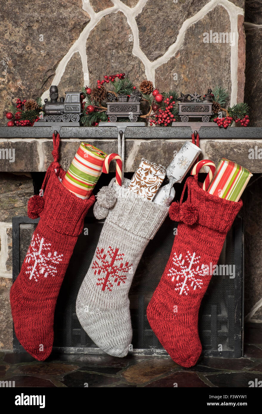 Calze ripiene appesi ad un camino la mattina di natale Foto Stock