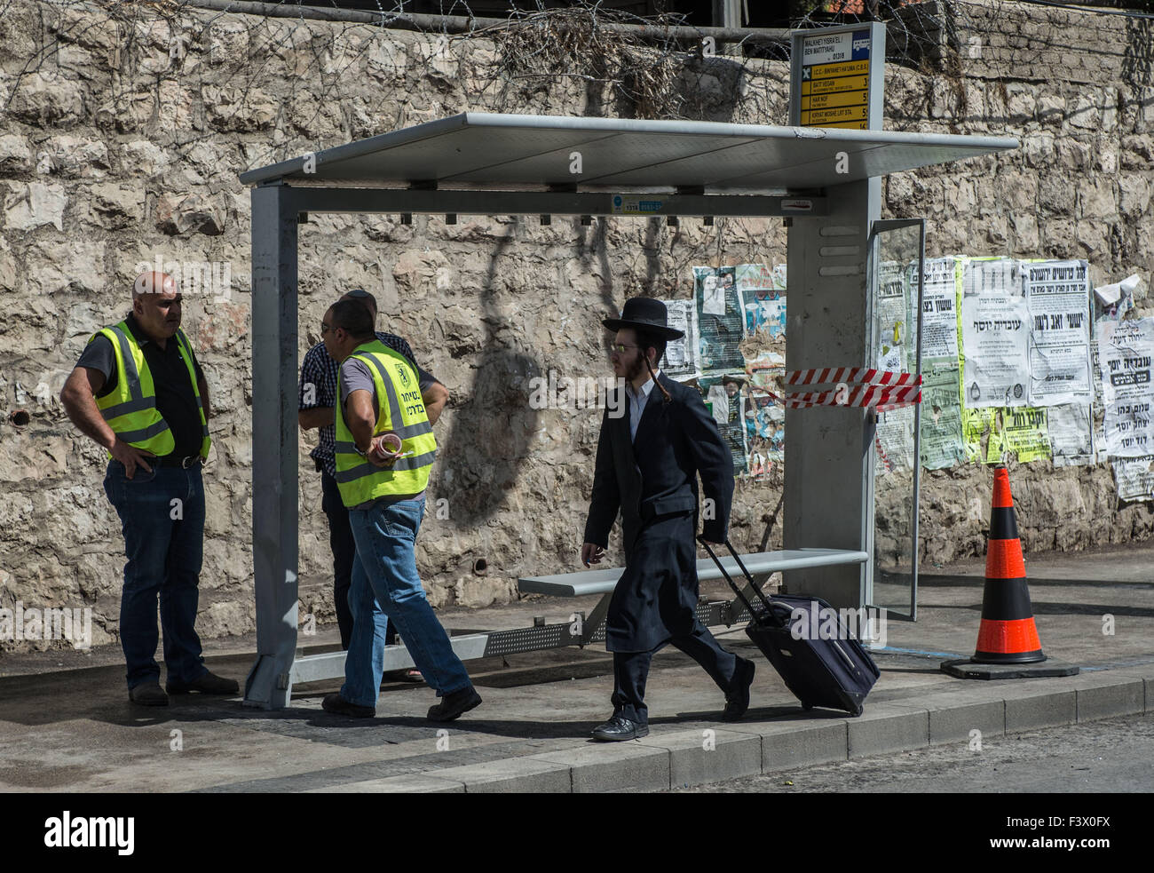 (151013) -- Gerusalemme, 13 ottobre, 2015 (Xinhua) -- Un ultra-ebrea ortodossa uomo cammina passato il sito di una stazione degli autobus attentato a Gerusalemme, su 13 Ottobre, 2015. Almeno tre israeliani sono stati uccisi e 26 altri feriti in quattro attacchi di palestinesi a Gerusalemme e la città di Ra'anana Martedì mattina la polizia israeliana detta. Un palestinese su un furgone con il logo di Israele nazionale di telecomunicazioni della società, Bezeq, correva su pendolari in corrispondenza di una stazione di autobus in Geula quartiere nel centro di Gerusalemme. Egli si è poi recato al di fuori del suo veicolo, che trafigge i passanti con un coltello. Servizi di salvataggio ha detto che ha ucciso uno e injur Foto Stock