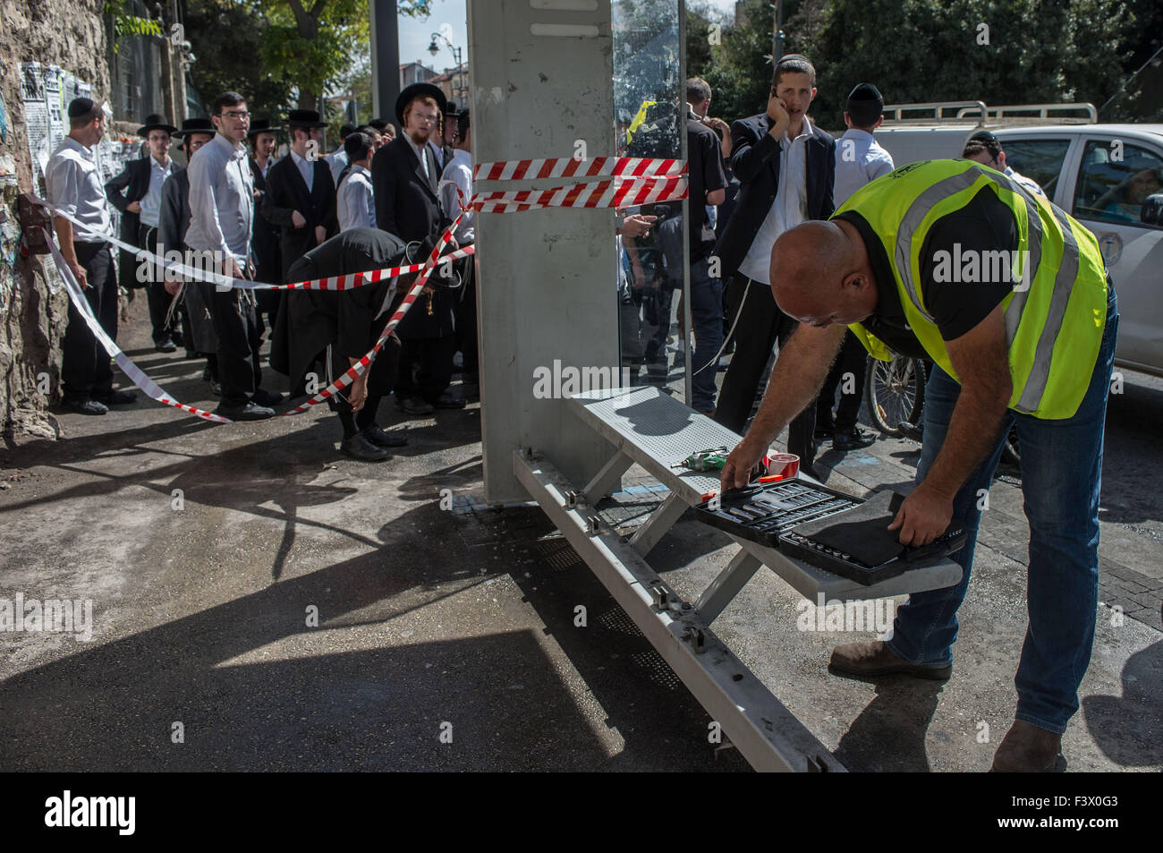 (151013) -- Gerusalemme, 13 ottobre, 2015 (Xinhua) -- Un lavoratore israeliano le riparazioni una stazione degli autobus dopo un attentato a Gerusalemme, su 13 Ottobre, 2015. Almeno tre israeliani sono stati uccisi e 26 altri feriti in quattro attacchi di palestinesi a Gerusalemme e la città di Ra'anana Martedì mattina la polizia israeliana detta. Un palestinese su un furgone con il logo di Israele nazionale di telecomunicazioni della società, Bezeq, correva su pendolari in corrispondenza di una stazione di autobus in Geula quartiere nel centro di Gerusalemme. Egli si è poi recato al di fuori del suo veicolo, che trafigge i passanti con un coltello. Servizi di salvataggio ha detto che ha ucciso e ferito almeno cinque Foto Stock