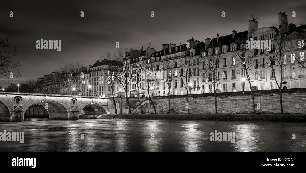 Senna, Quai de Bourbon sulla Ile Saint Louis con Pont Marie e luci della sera. Fila degli edifici del XIX secolo, Parigi, Francia Foto Stock