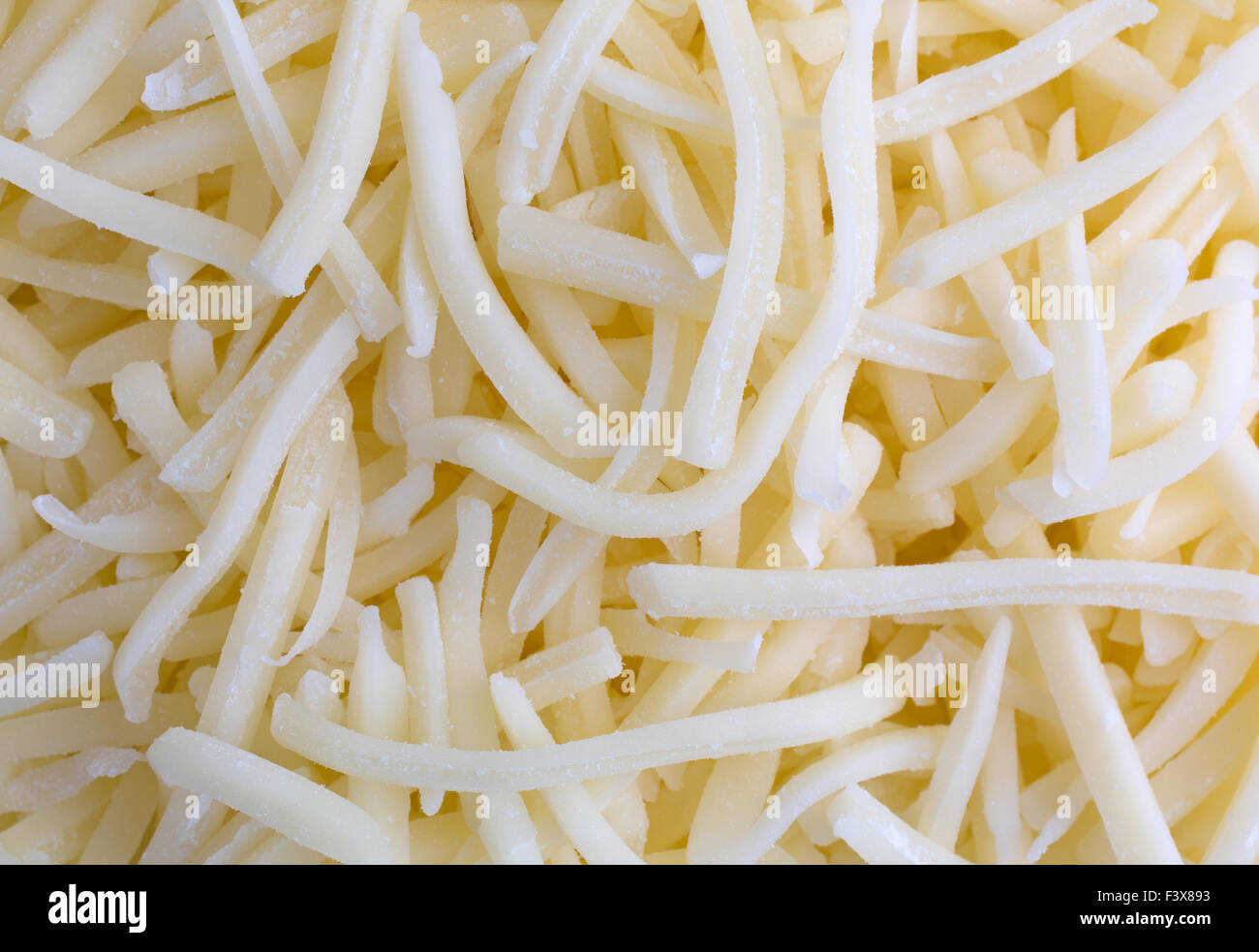 Top vista ravvicinata del bianco naturale dolce formaggio cheddar illuminato con luce naturale. Foto Stock