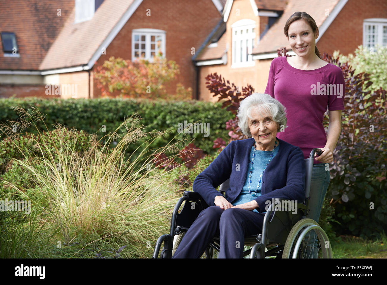 Figlia di spinta madre Senior in carrozzella Foto Stock