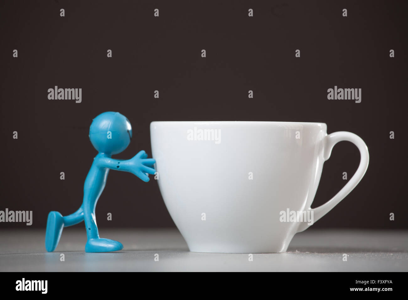 Blue man spingendo e tazza di caffè. Foto Stock