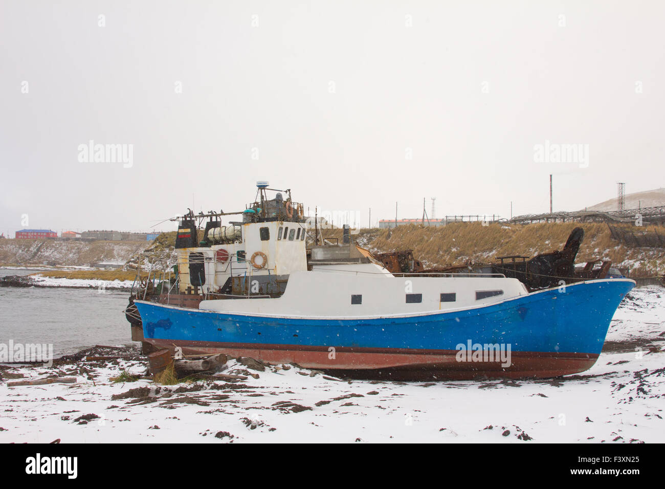 La barca sulla riva del mare d'inverno Foto Stock