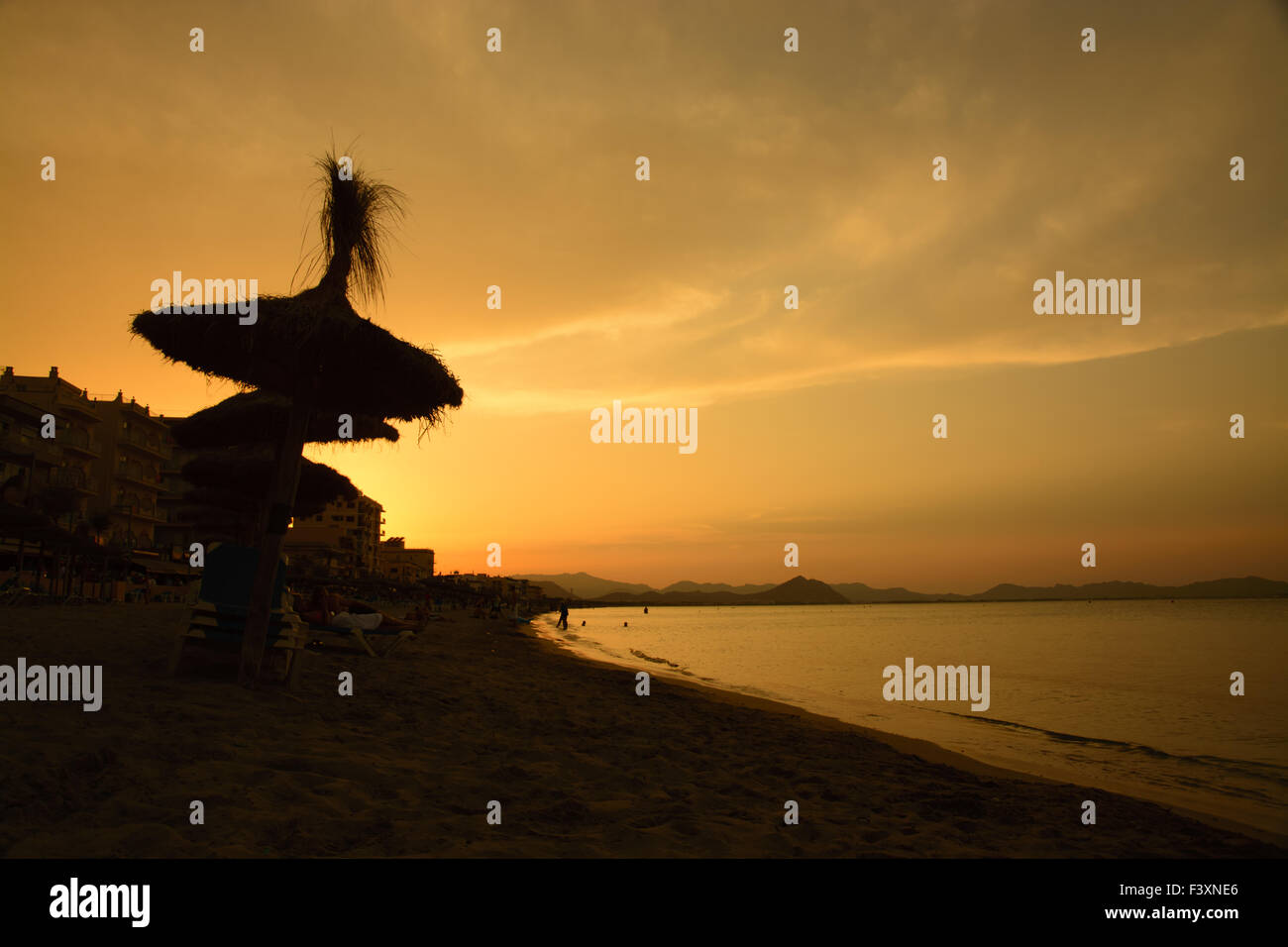 Tramonto con ombrelloni di paglia. Foto Stock