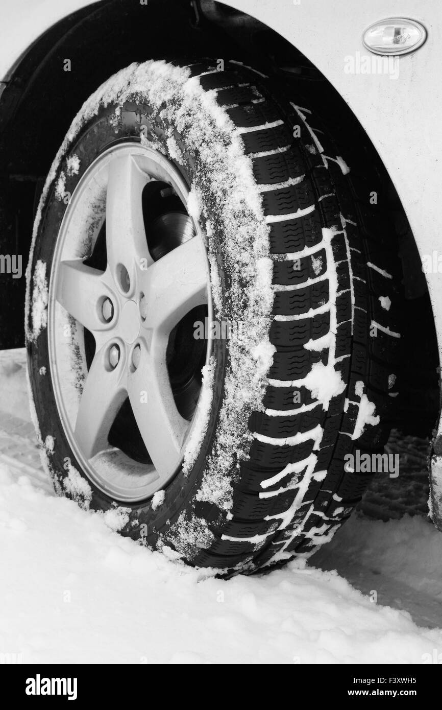 Close up di un auto pneumatici su una strada innevata Foto Stock