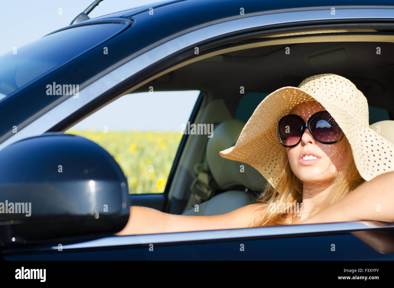 Donna alla guida a cappello e occhiali da sole Foto stock - Alamy