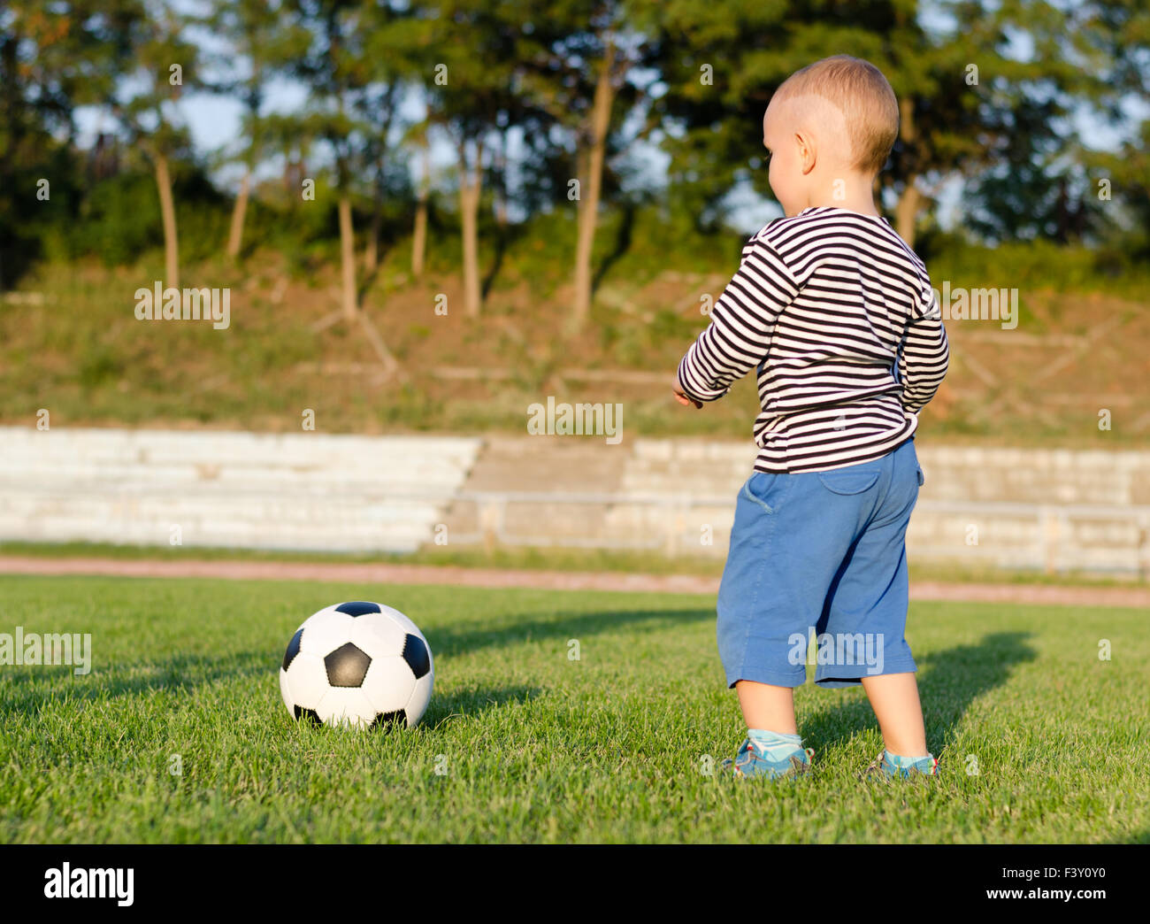 Little Boy imparare a giocare a calcio Foto Stock