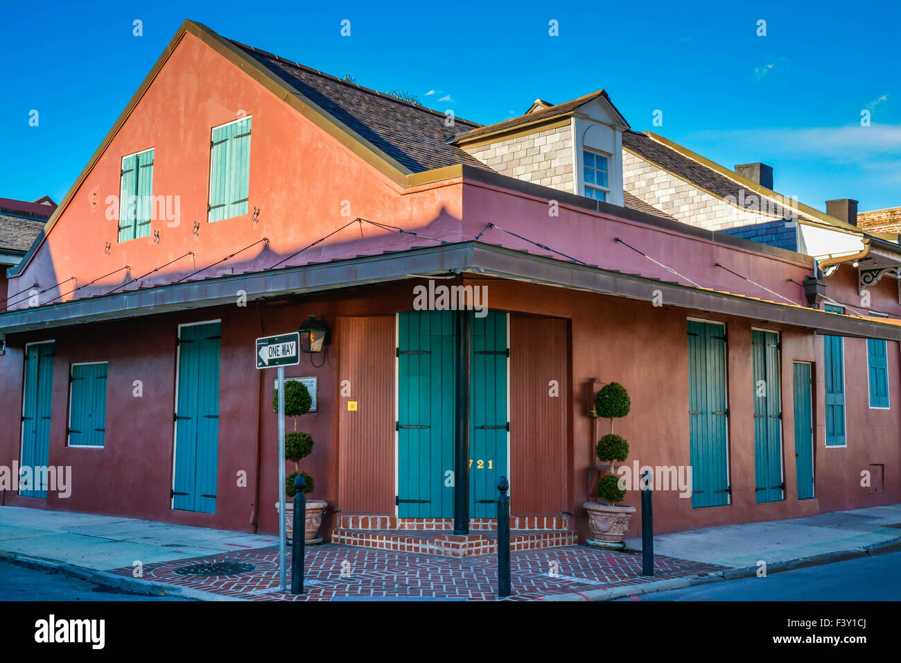 La colorata Vecchia edificio ad angolo con persiane verdi nel Quartiere Francese, New Orleans, LA Foto Stock