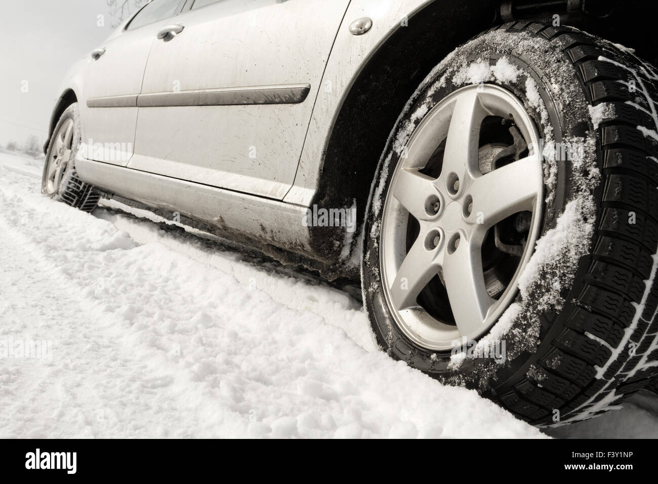 Close up di un auto pneumatici su una strada innevata Foto Stock