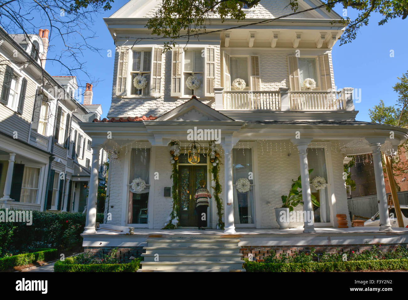 Un visitatore alla porta di un classico Quartiere Giardino mansion, decorata per le vacanze in New Orleans LA Foto Stock