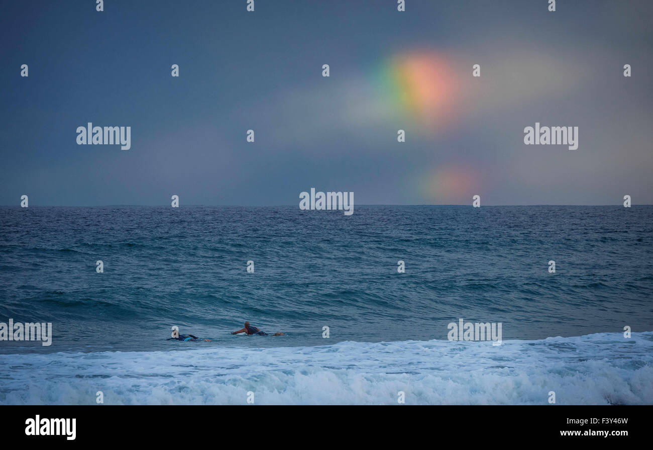 6 ott. 2015 - Lake Worth, Florida, Stati Uniti - Surfers paddle sotto un arcobaleno parziale alla sera onde che chiude il lago vale la pena di pier in Lake Worth, Fla., Martedì, Ottobre 6, 2015. (Credito Immagine: © Thomas Cordy/Palm Beach post via ZUMA filo) Foto Stock