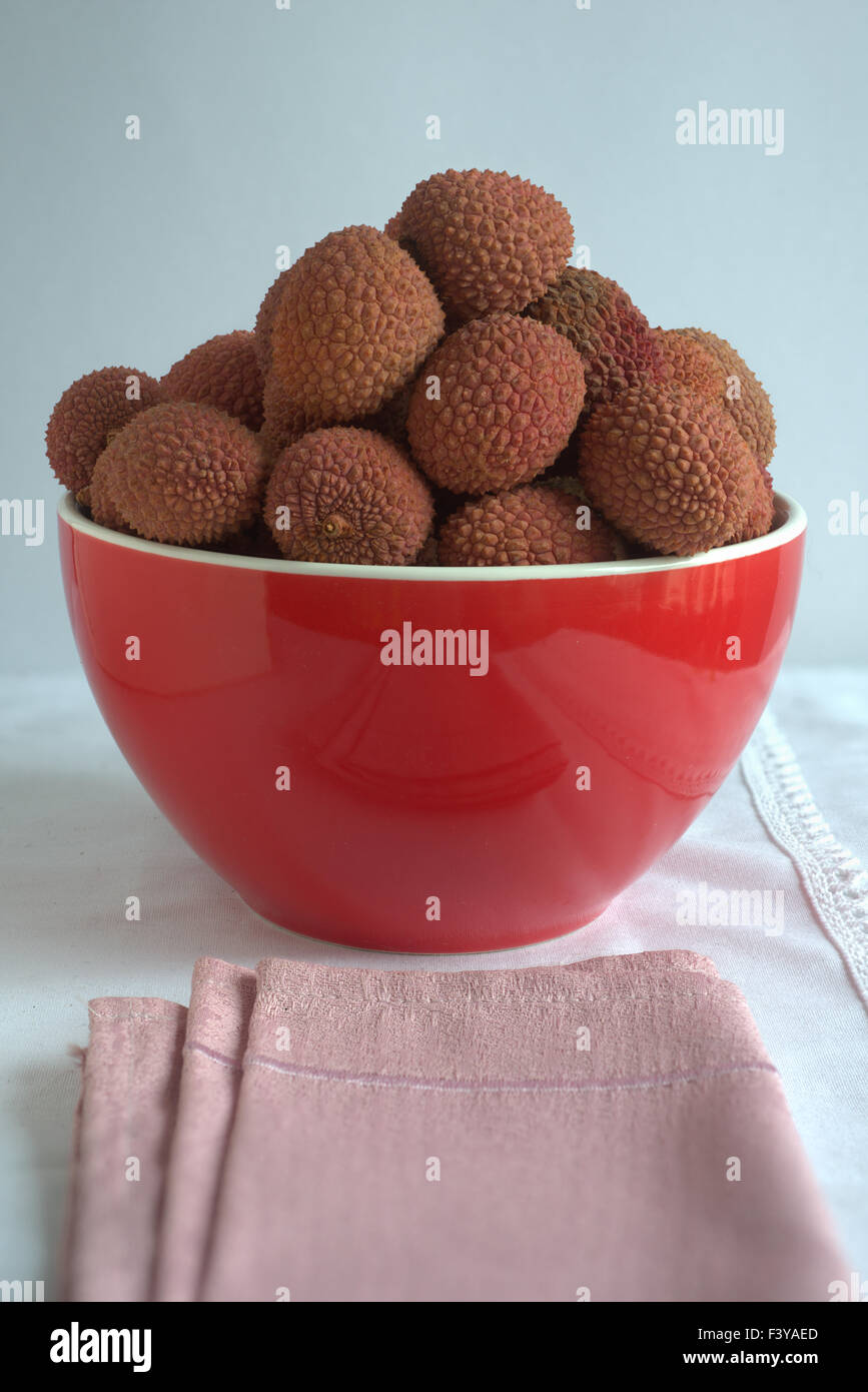 Recipiente rosso con i litchi Foto Stock