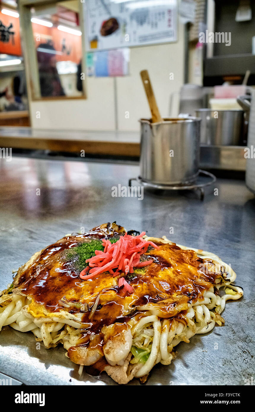 Giappone, isola di Honshu, Chugoku, Hiroshima, famoso cibo locale chiamato okonomiyaki. Foto Stock