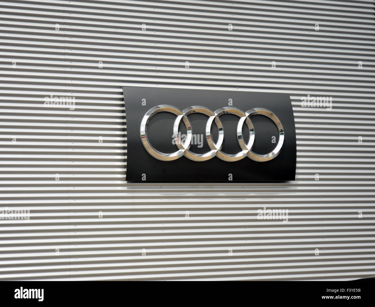 Un grande Audi automobili logo su un argento parete metallica al di fuori di un Audi auto concessionaria nel Regno Unito. Foto Stock