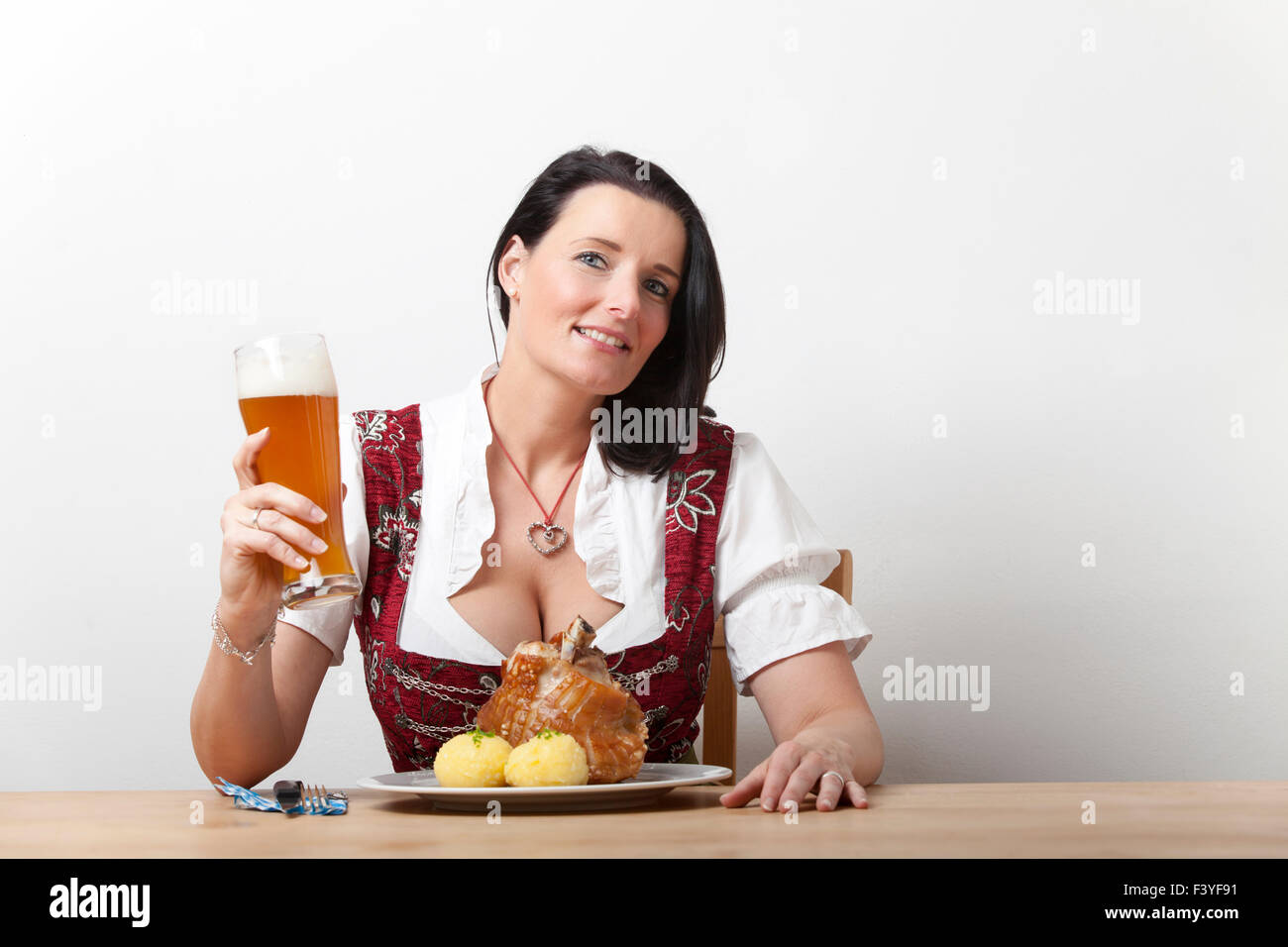 Donna bavarese in una camicetta con carne di maiale Foto Stock