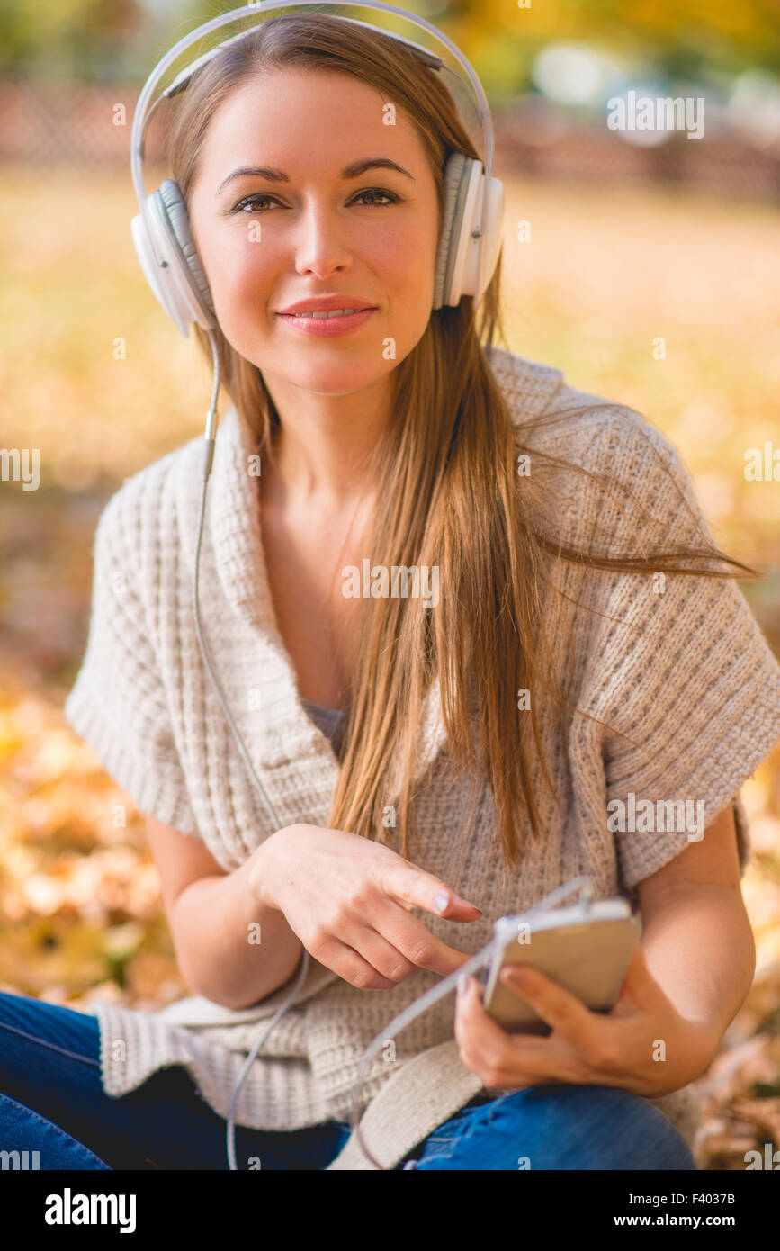 Donna attraente ascoltando la sua libreria musicale Foto Stock