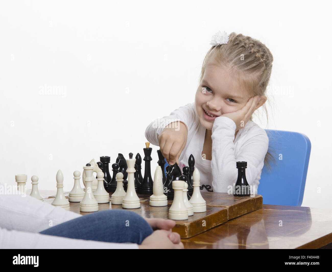 Ragazza che gioca a scacchi in un buon umore Foto Stock
