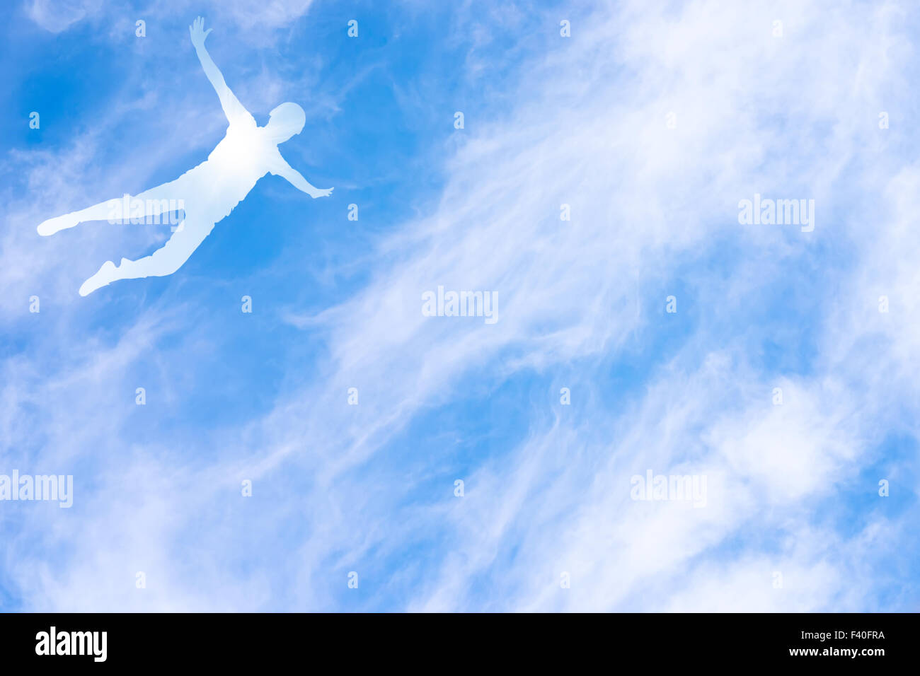 Sfondo con silhouette di un essere umano in volo contro il blu cielo molto nuvoloso Foto Stock