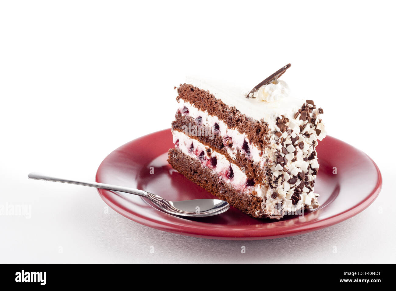 Torta multistrato sulla piastra con cucchiaino Foto Stock