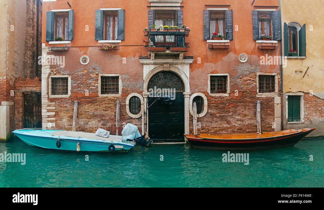 Due barche a motore accanto all'ingresso della casa Foto Stock