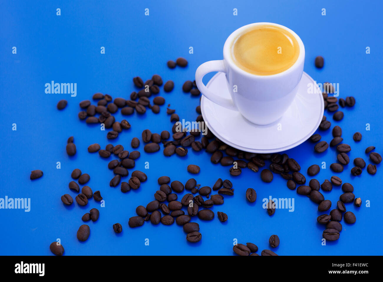 Tazza di caffè e fagioli su un tavolo blu Foto Stock