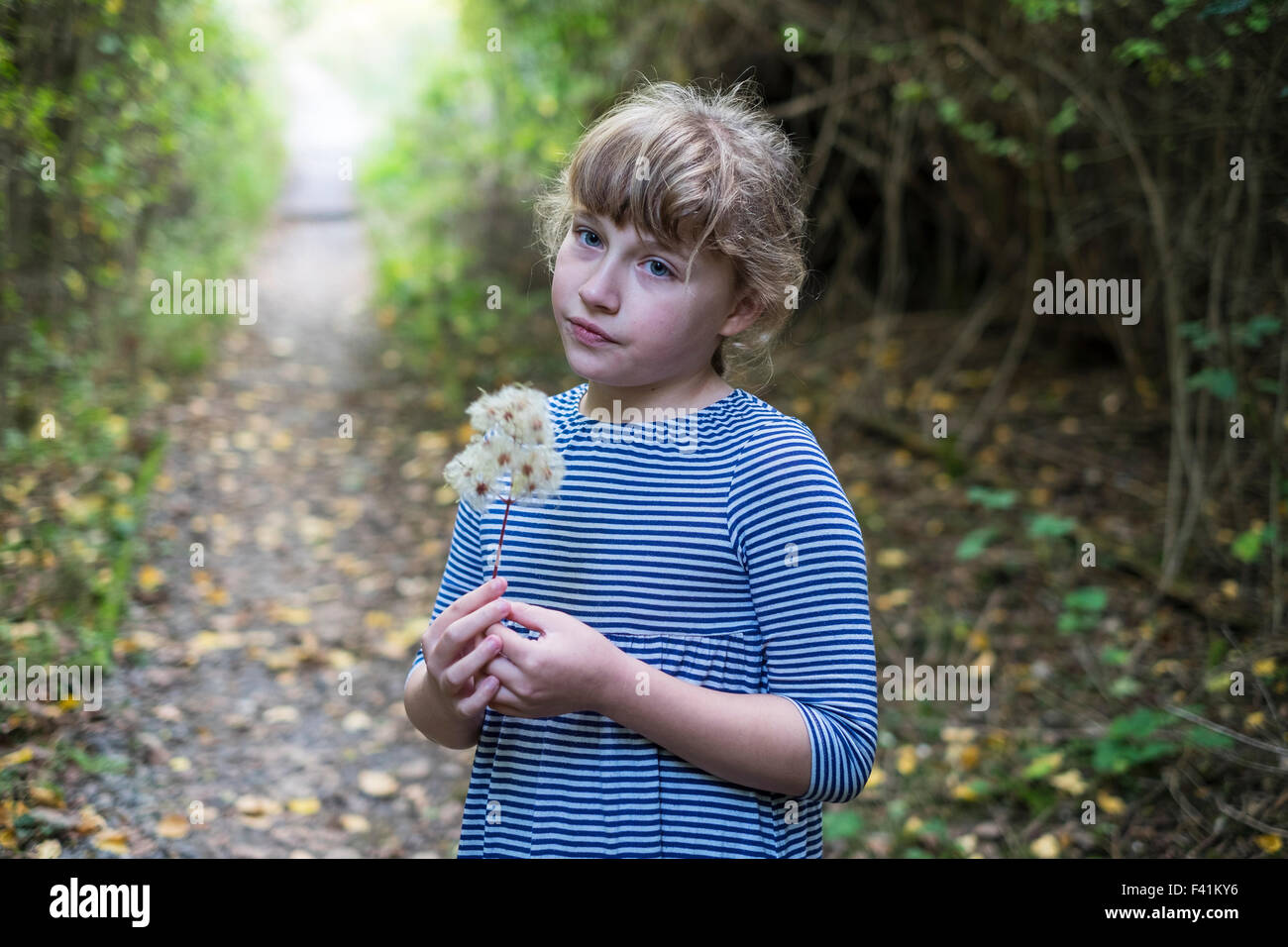 11 anno vecchia ragazza guarda pensieroso nel bosco Foto Stock