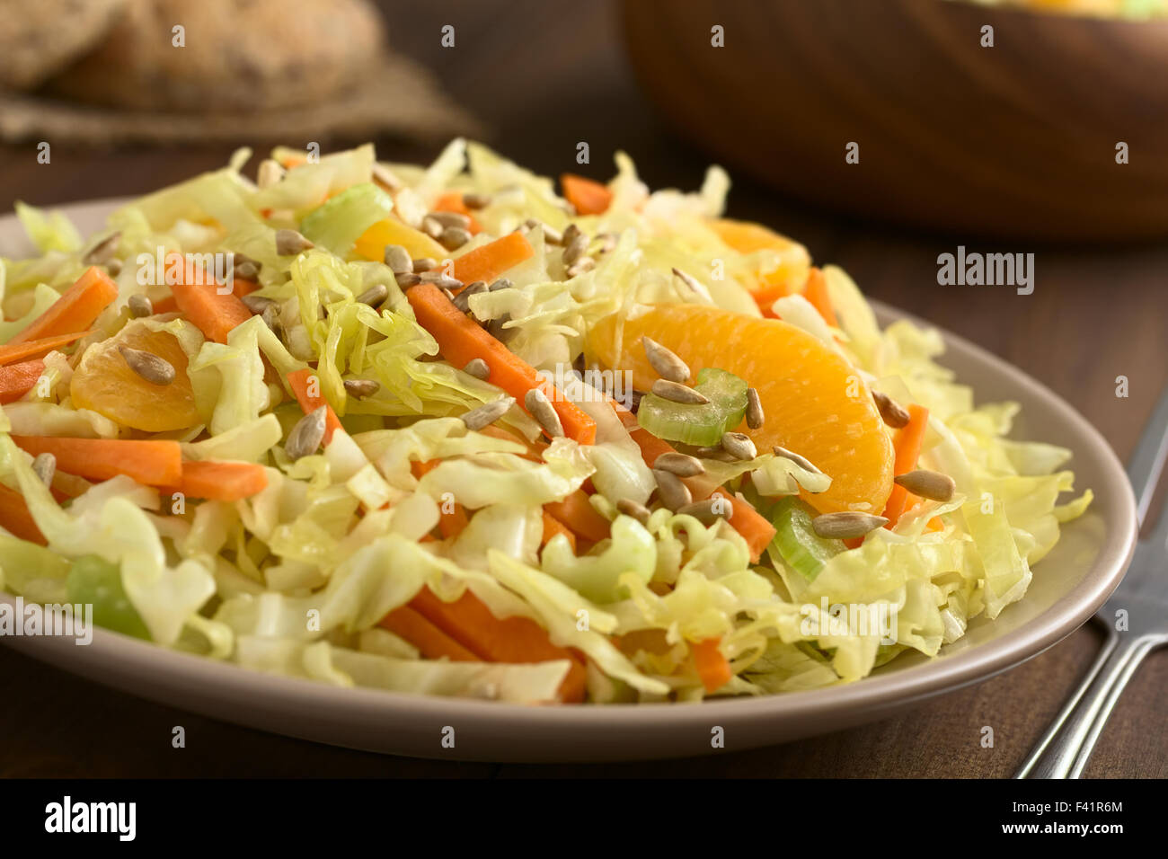 Insalata fresca fatta di cavolo verza, la carota e il sedano e arancione con arrosti di semi di girasole sulla parte superiore Foto Stock