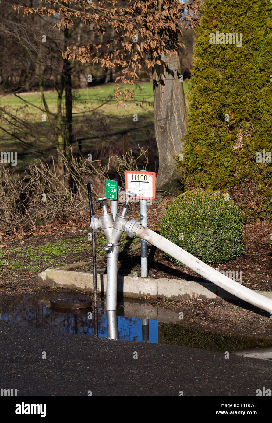 Vigili del fuoco con acqua di idranti e manichette Foto Stock