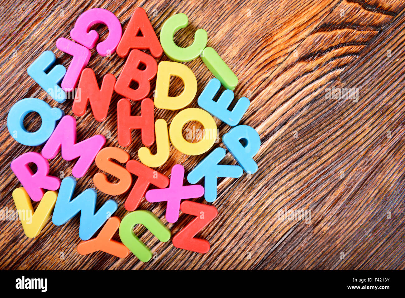 Composizione di materia plastica colorata alfabeto lettere sullo sfondo di  legno Foto stock - Alamy