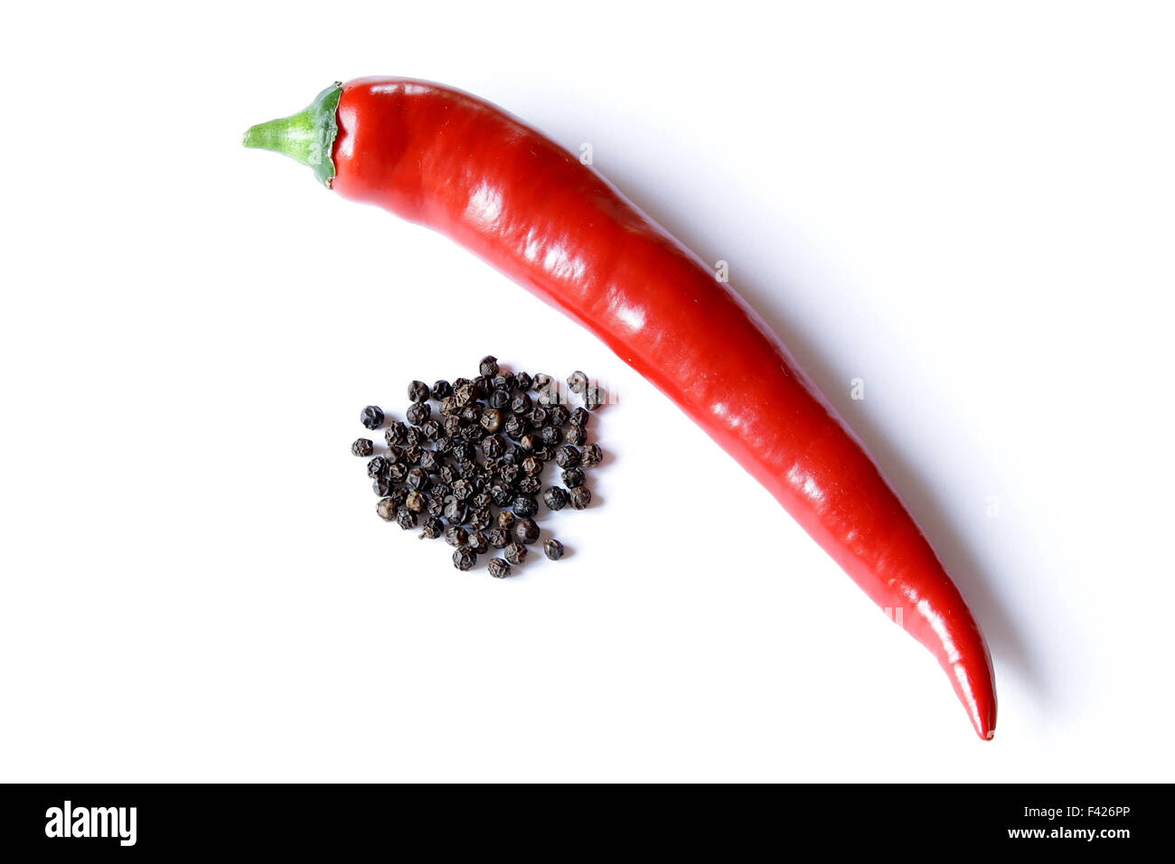 Long red hot pepper shiny su sfondo bianco con secchi peperoni nero Foto Stock