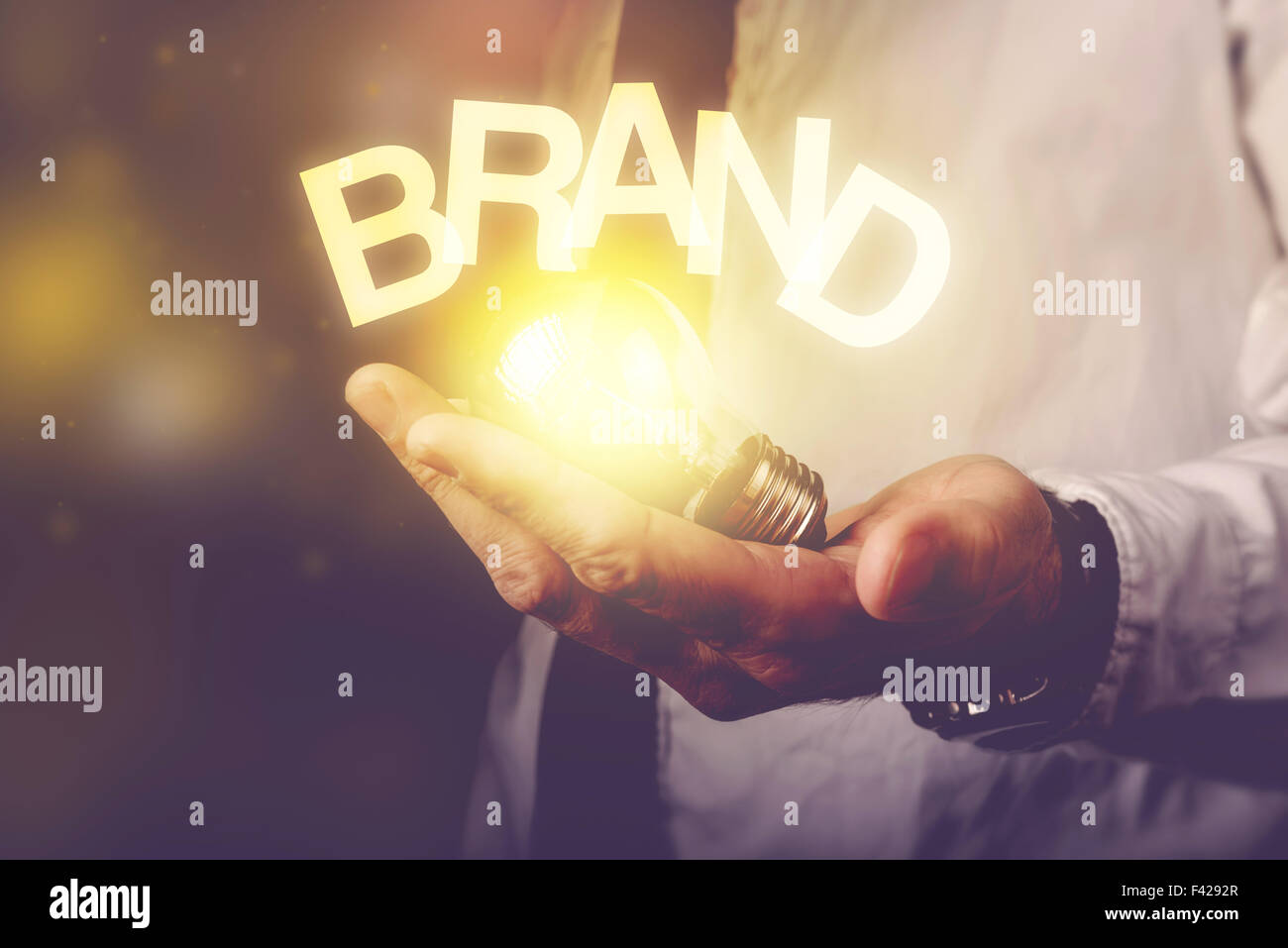 Marca idea nozione di imprenditore tenendo lampadina, dai toni rétro immagine, il fuoco selettivo. Foto Stock