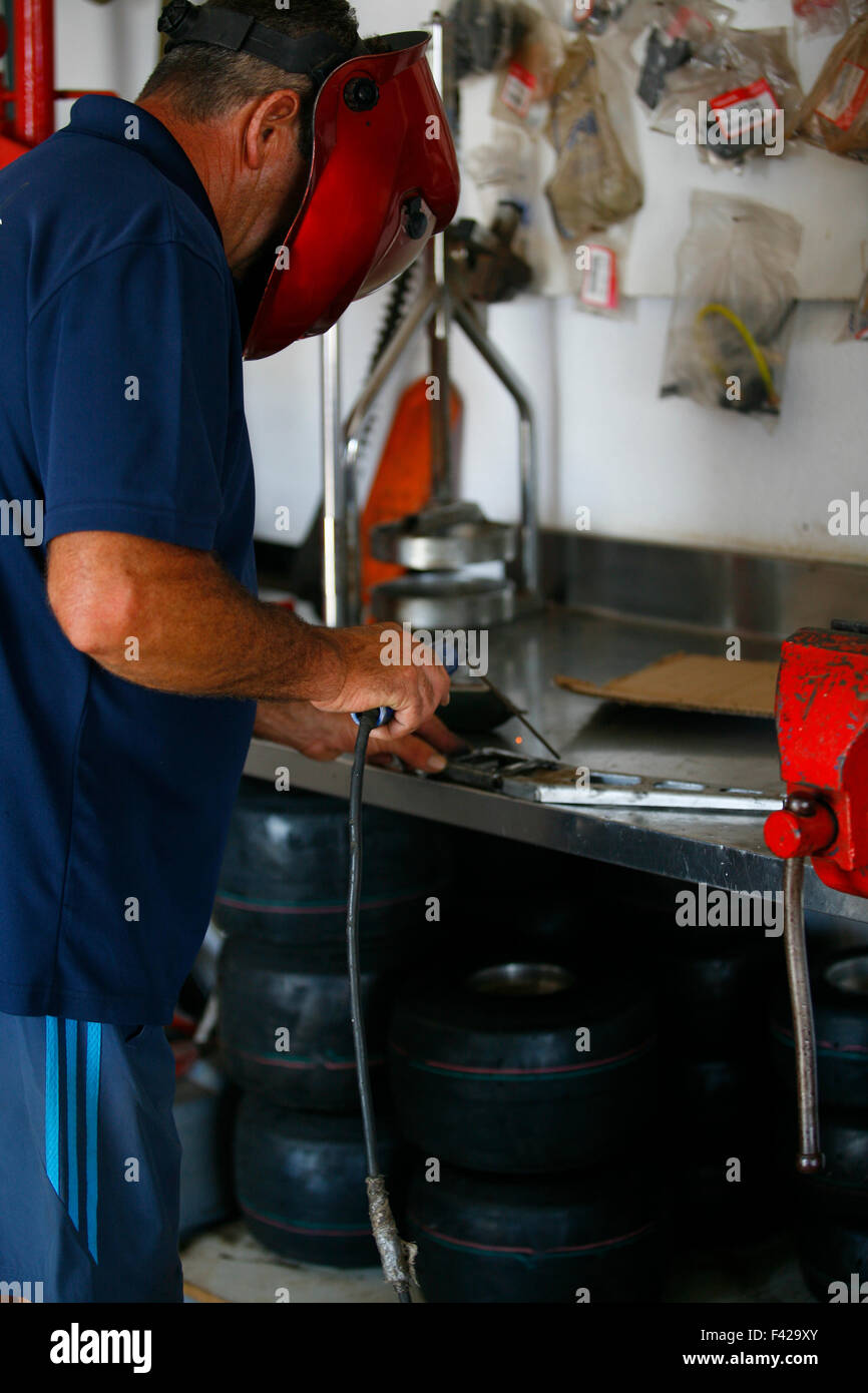Latino latino maturo saldatore maschio con apparecchiature per saldatura su un worshop carrelli Foto Stock