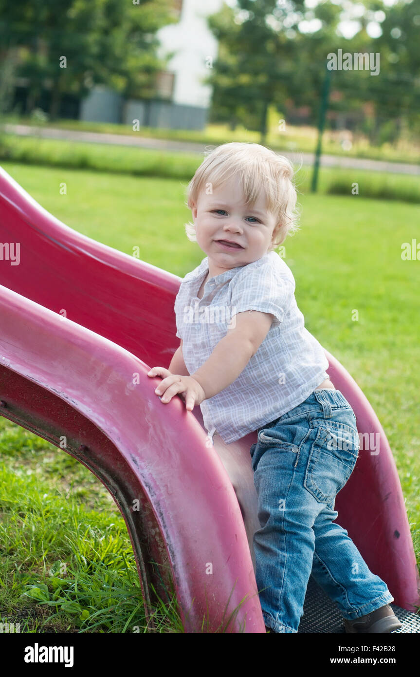 Sorridente bambino che gioca su un bambino slitta Foto Stock