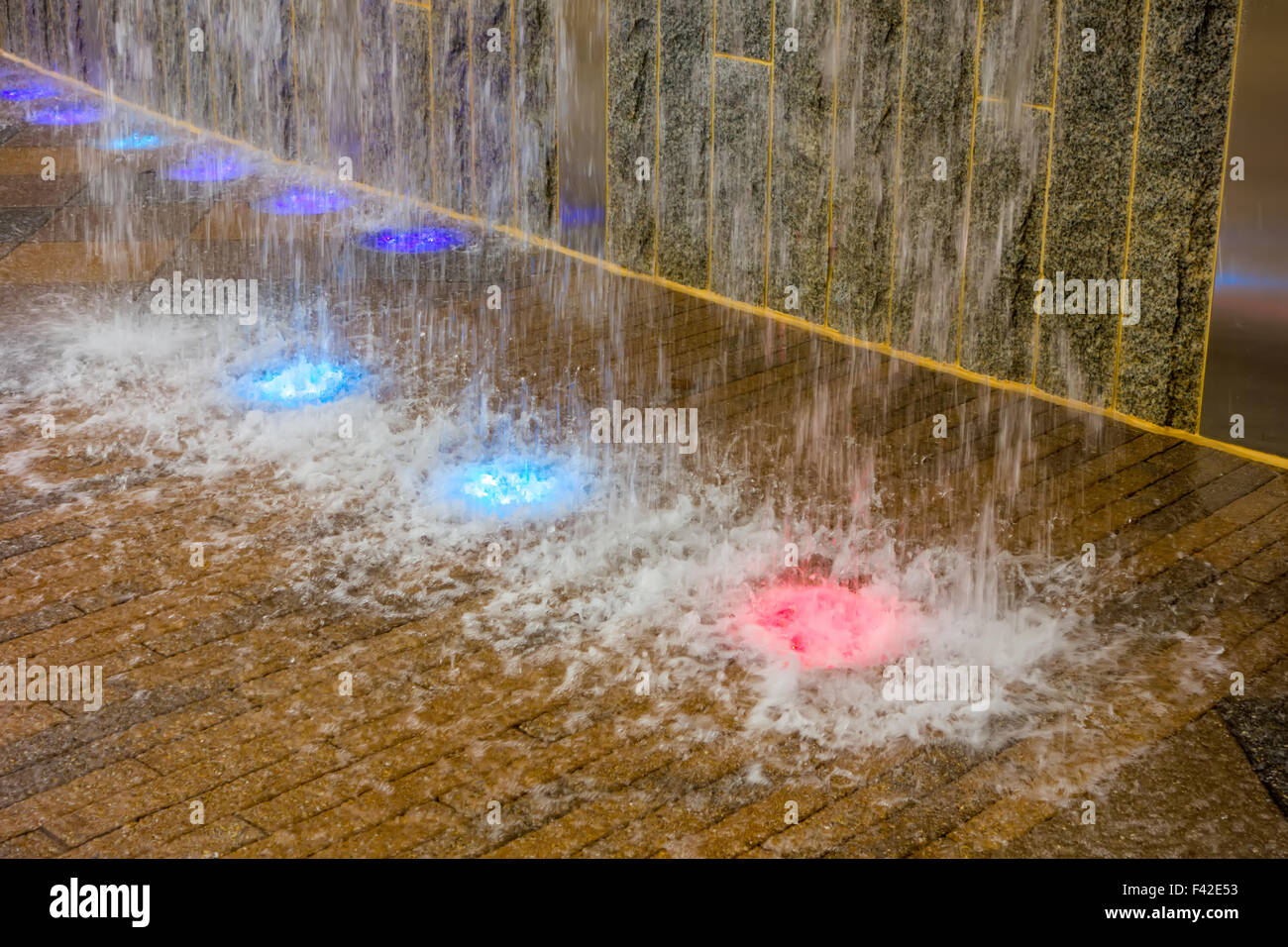 Cascata artificiale con colorate luci a led Foto Stock