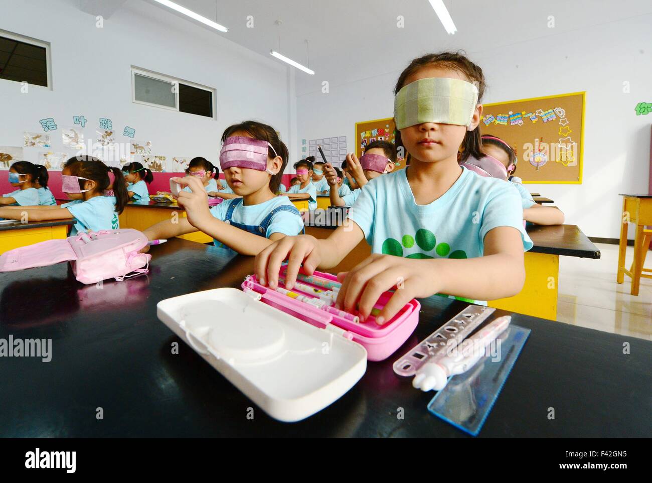 Shijiazhuang, bastone bianco giorno di sicurezza. Xiv oct, 2015. I bambini in una scuola primaria prendere parte ad attività extracurricolari per sperimentare la vita delle persone cieche in Xingtai, nel nord della Cina di nella provincia di Hebei, precedendo il Bastone bianco giorno di sicurezza, il 14 ottobre 2015. Ottobre 15 segna il Bastone bianco il giorno di sicurezza per celebrare i successi delle persone non vedenti o le persone con minorazione visiva. © Zhu Xudong/Xinhua/Alamy Live News Foto Stock