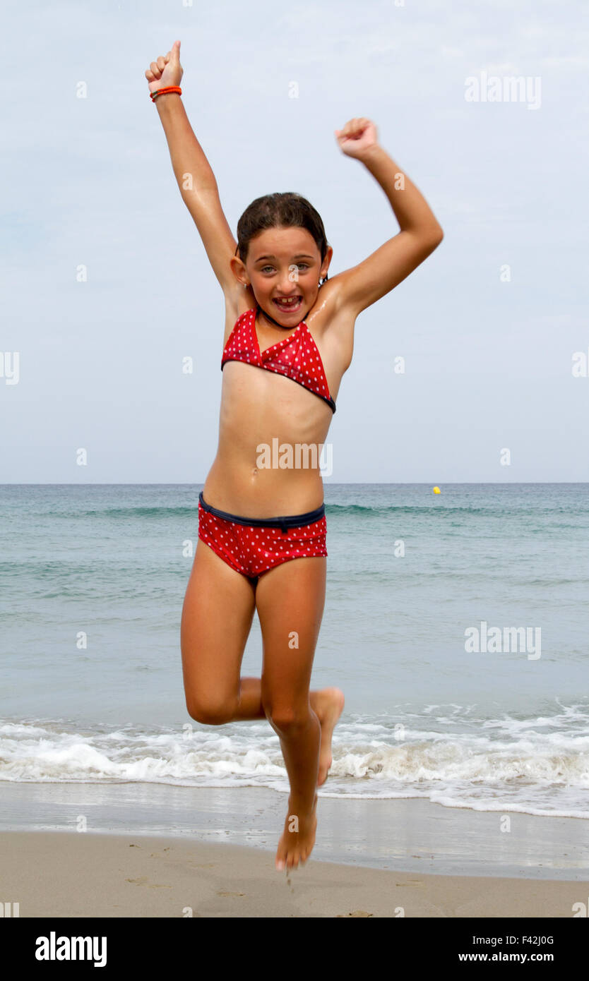 Happy girl jump sulla spiaggia Foto Stock