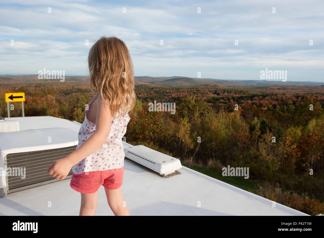 Bambina in piedi sulla parte superiore del motore home, guardando alla vista panoramica Foto Stock